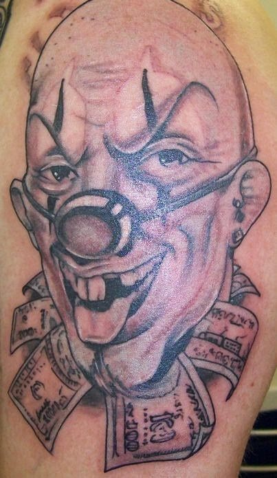 Payaso calvo y del cuello lo salen billetes, pero no es ese el detalle más macabro de este tatuaje en el que resalta la nariz tan peculiar de este payaso y los dientes, bueno, los que se han tatuado y los pendientes del payaso, sin duda, estamos ante un payaso distinto al que acostumbramos a ver, pero ahí residen la magia de tu tatuaje en que te sorprenda lo típico, en la peculiaridad de los motivos que quieras añadirle a tu tattoo