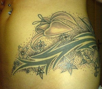 Tatuaje con motivos florales y puntos negros que ocupa el abdomen y parte de la espalda de esta chica, un tatoo muy sexy