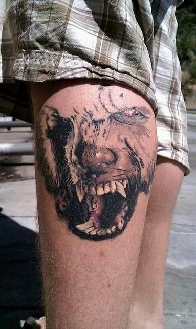 Extrao diseo que mezcla rasgos de un lobo y humanos tatuados en el muslo de este chico