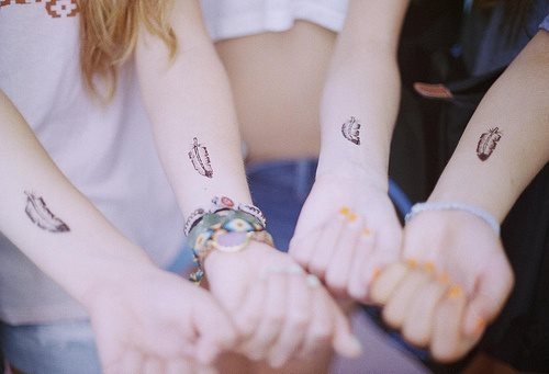 Este grupo de amigas comparten el diseo de una pluma tatuadas en la parte superior de la muecas, en el antebrazo