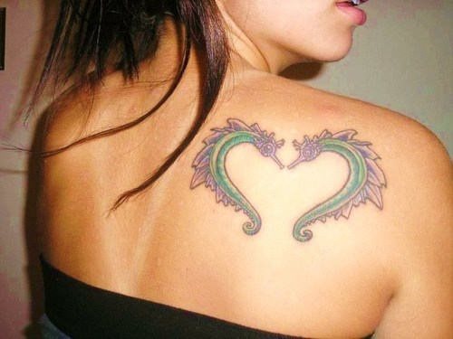 Dos caballitos de mar forman un corazón tatuado sobre la espalda con unos colores muy de moda, el morado y el verde, colores que cada vez se están viendo más en los últimos diseños que os estamos mostrando