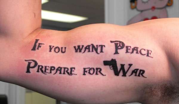 En esta ocasión nos encontramos con un tatuaje en el brazo con la frase If you want Peace, prepare for War, un tatuaje un tanto contradictorio, del que nos gusta que se haya jugado con los símbolos y las palabras, ya que en la palabra de paz se ha incluido el símbolo clásico de la paz y en la palabra guerra se ha tatuado una pistola que forma la letra w