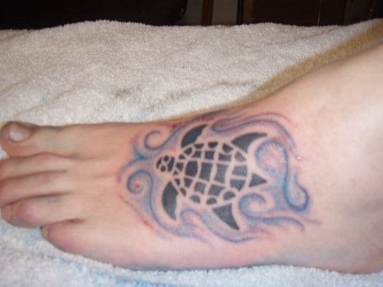 En la siguiente imagen nos encontramos con un tatuaje situado en el empeine de esta persona, en el cual se puede ver la silueta de una tortuga que nada entre unas aguas con remolinos