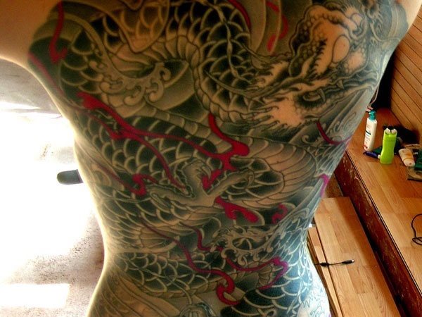 Tatuaje que ocupa toda la espalda, es un dragón, pero lo que más se puede apreciar es el cuerpo y las enormes y bonitas escamas que se le han realizado, además de los pequeños trazos en rojo que le dan un aspecto impresionante a este tattoo ideal para los amantes de los dragones