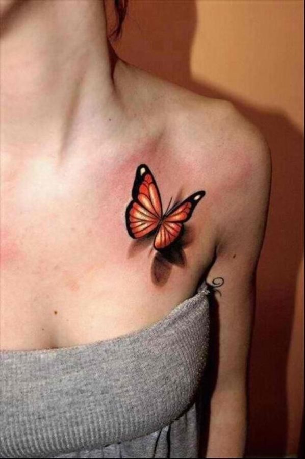 Tatuaje muy femenino de una mariposa a colores naranjas y negros, con una pizca de toques blancos que se ha tatuado sobre el pecho de una chica, un tatuaje sencillo y que queda realmente bonito sobre la piel