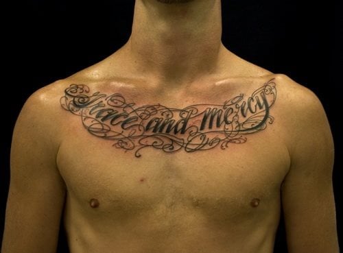 Tatuaje en el pecho donde la gran cantidad de cenefas con las que se ha querido envolver todo el tatuaje, impiden que se pueda apreciar con claridad las palabras que este hombre ha tatuado sobre su pecho, casi en el cuello