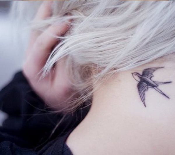 Pequeño diseño sobre la nuca de una golondrina en pleno vuelo, un tatuaje muy acertado para una chica y que es fácil de disimular dejando caer su pelo, así sólo mostrará cuando ella quiera, si es que quiere mostrarlo