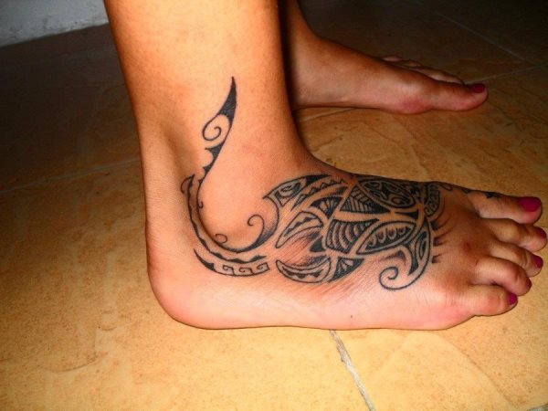 Otro diseño de estilo maorí de una tortuga marina tatuado en el empeine de esta chica