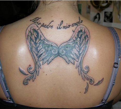 Tatuaje en la espalda de unas alas a las que algunas plumas se están cayendo como si el viento se las estuviera llevando y en la que se ha tatuado una frase italiana en honor al padre de esta chica, un tatuaje muy emocional para todas aquellas personas que quieran regalarle una muestra de amor a sus padres