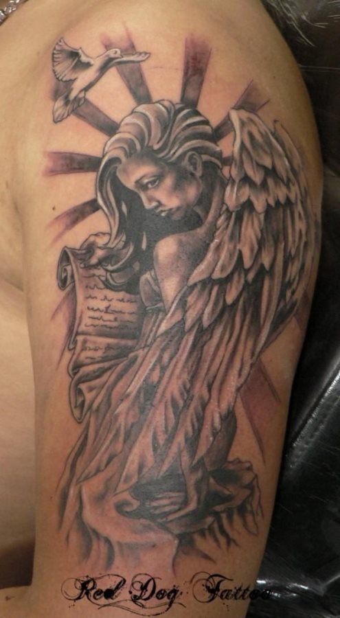 De nuevo el tatuaje de la mujer ángel presidido por una paloma en la parte superior del tatuaje y caracterizado por tener entre sus manos un manuscrito, de este tatuej nos gustaría destacar la gran belleza de la mujer y el gran trabajo de todos los sombreados y los destellos que salen del propio ángel