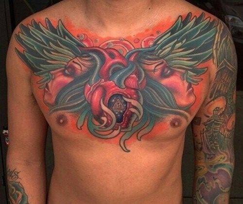 Tatuaje en el pecho de un corazón sobre dos caras de mujer con gran pelo y donde se ha jugado con las alas y el pelo, utilizando los mismos colores para que dé la sensación de estar envolviendo todo el tatuaje y que sin duda, esa sabia elección, lo ha catapultado a convertirlo en uno de los mejores tatuajes en el pecho que hemos visto hasta ahora