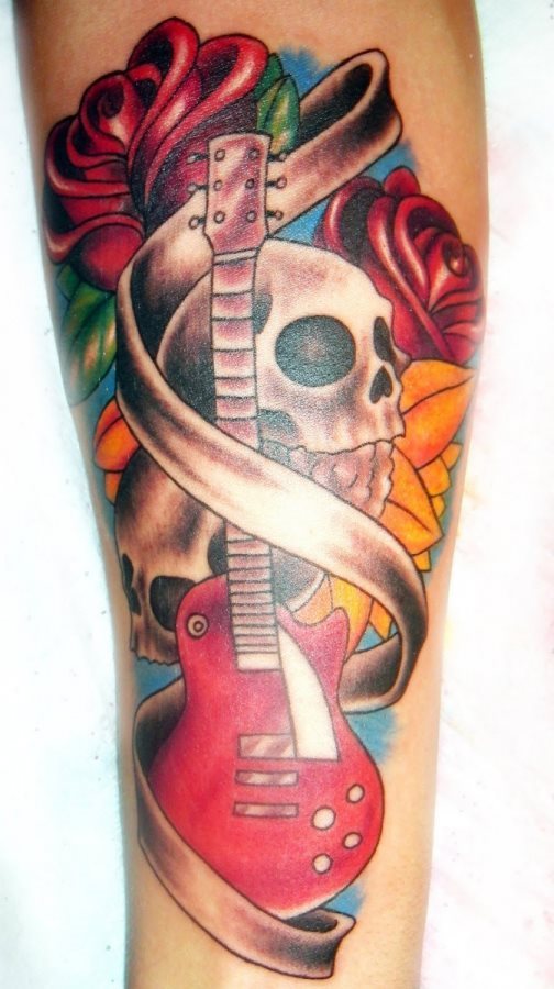 Tattoo musical con una guitarra en la parte central y al fondo una calavera y varias flores