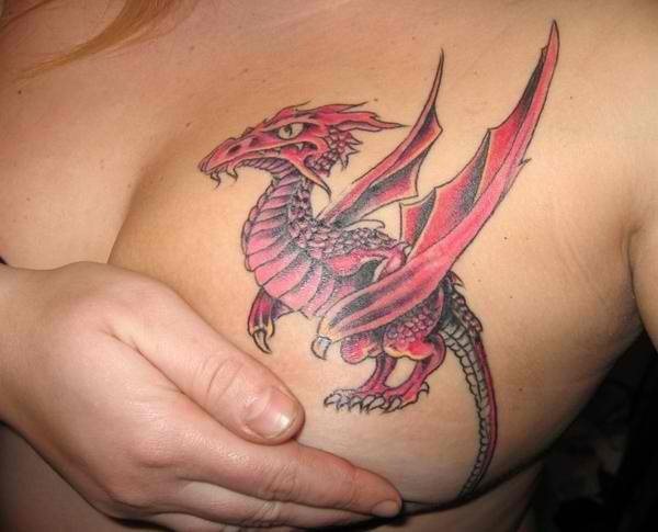 Tatuaje de un dragón rojo con grandes alas que ha sido tatuado en el pecho izquierdo de esta mujer, llegando los trazos incluso a ser dibujados sobre parte de los senos, dando como resultado un tattoo muy sensual y sexy