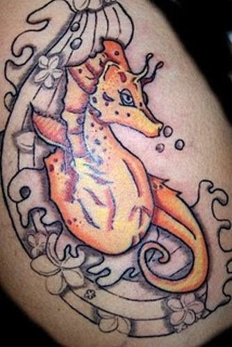 Tatuaje de un caballito de mar en tonos naranjas, al que vemos se está copletand con un espectacular oleaje, que cuando esté terminado quedará genial en la piel de esta persona