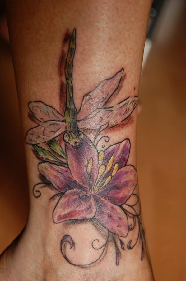 Diseo de una lubelula sobre una flor, tatuada con un colorido y un saturado que le aportan personalidad repecto a otros diseos que hemos podido observar en otras ocasiones