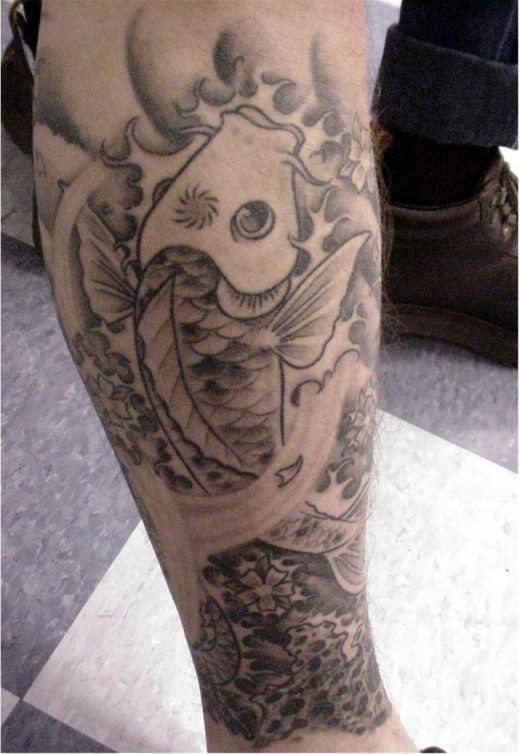 Carpa koi tatuda en la pierna, tatuada en tonos negros con sombreados y texturas diferentes que le aportan contenido y perspectiva al diseo