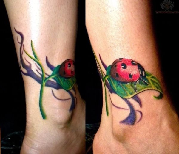 Tatuaje en los tobillos de unas mariquitas posadas sobre unas hojas verdes y de fondo un sombreado de ramas más oscurecidas, un tatuaje muy simpático y colorido en el que se han resaltado los colores rojo y negro de la mariquita y se le ha dado un importancia a los brillos y reflejos de la mariquita para que se obtenga tan buen tatuaje