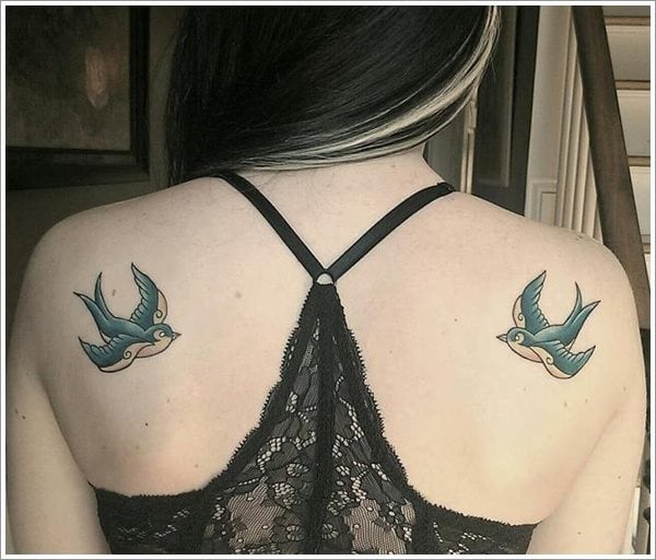 Dos golondrinas simétricamente tatuadas en ambos lados de la parte superior de la espalda, conforman el tatuaje de esta chica que podría ser completado con algún lazo de pico a pico de la golondrina, en el que poder tatuar alguna frase, de todos modos así está muy bien