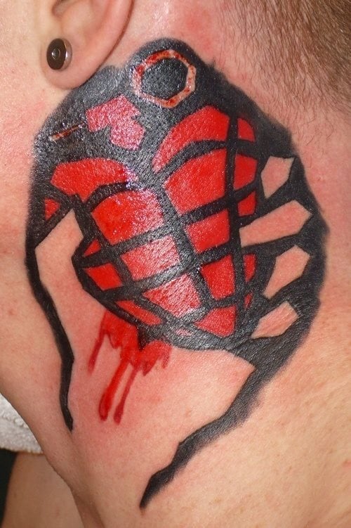 Tatuaje de una especie de granada roja realizada sobre el cuello de un hombre, un tatuaje basatnte original porque si nos fijamos se ha tatuado un corazón ensangretado y gracias a los trazos y el fondo negro se ha conseguido la forma de la granada