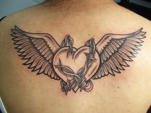 Tatuaje de un corazón envuelto por un alambrado de espino y custodiado por unas alas totalmente abiertas, creemos que a este tatuaje si se le hubiera acompañado de algo de color no hubiera quedado tan bien como ha quedado así en negro y sin rellenar, sólo jugando con los sombreados
