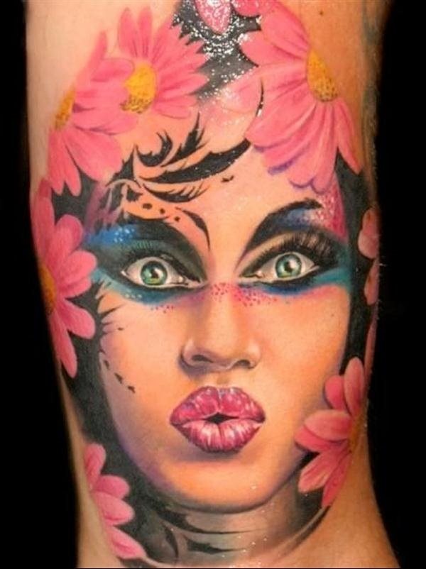 Preciosa la cara tatuada con el maquillaje a grandes colores viviso y rodeados por unas preciosas margaritas rosas, sin duda un tatuaje espectacular, al igual que la belleza de la cara tatuada y la mirada tan bonita que tiene