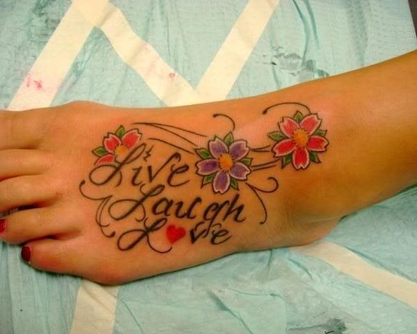 Palabras rodeadas de coloridas flores ocupan este tatuaje sobre el empeine de esta chica, un tatuaje cargado de simbolismo y colorido, que no es necesario contemplar durante un largo tiempo para entender su significado, ya que las propias palabras nos indica lo que se quiere transmitir, si es que quiere transmitir algo más allá que a ella misma