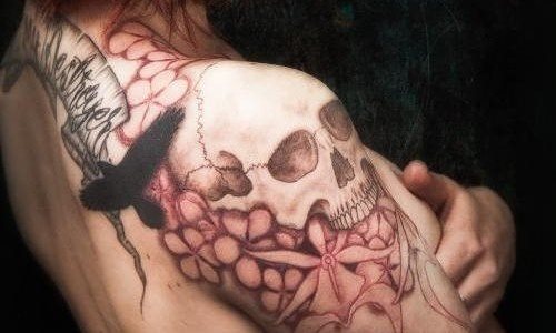 Tatuaje formado por una calavera, algunas flores sin rellenar que rodean la paloma y una frase en la parte superior que cubre toda la parte de debajo del cuello