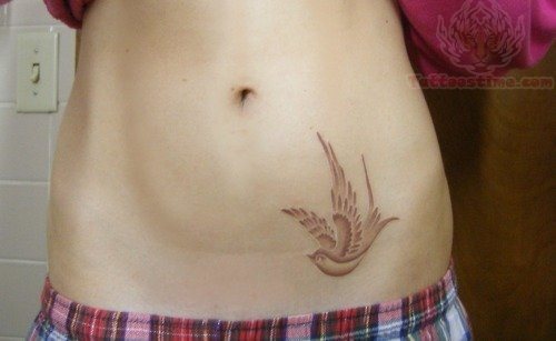 Sencillo diseño en tinta rojiza tatuado sobre el abdomen, tal vez no sea el tatuaje que más pueda durar y que necesite unos retoques el día de mañana, pero a día de hoy estamos ante un buen trabajo, sobre todo por el acabado de las plumas formado por pequeñas plumas que van formando el gran plumaje de este tatuaje