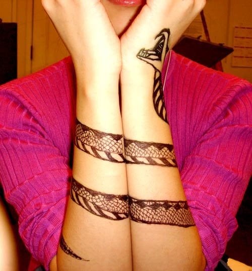 Esta chica se ha tatuado los dos brazos formando el cuerpo alargado de una serpiente con ambos brazos