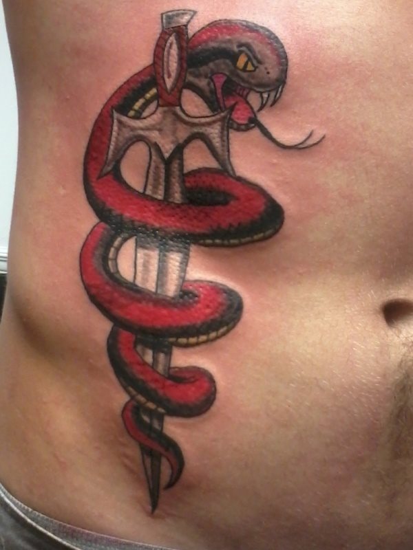 Tatuaje de una serpiente en tonos rojizos alrededor de una espada tatuado en un lateral del ombligo