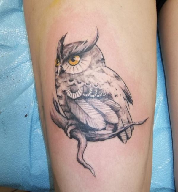 Tatuaje de un buho en la pierna, para el que ha sido un gran punto positivo el tatuarlo de negro y colorear los ojos en amarillo, una bonita idea para destacar alguna parte del tattoo o simplemente para dotar de belleza aún más al animal