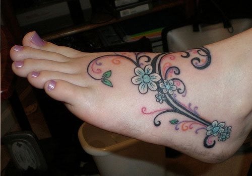 Ribetes negros decorados con otros más pequeños de colores y unas florecillas en tonos celestes y blancos dan juego a este pie haciendo un tatuaje con mucha fuerza y dinamismo, sin duda un buen tatuaje