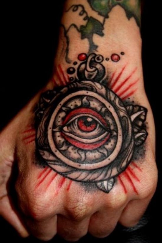 Ojo de color rojo tatuado en la mano de un hombre o chico joven