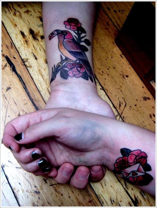 A los enamorados que les gustan los tatuajes, más de una vez han fantaseado con la idea de dejar marca sobre su piel de todo el amor que sienten, esta pareja lo ha hecho tatuando un pajarillo que sobre su pico lleva una carta, suponemos que de amor y la otra persona se ha tatuado una flor que sobre ella parece lleva la carta de amor que el pajarillo tenía sobre su pico