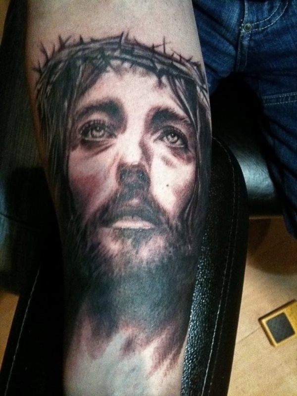 Tatuaje de la cara de Cristo en los últimos momentos antes de ser crucificado, que se ha tatuado en le antebrazo utilizando para ello sólo el color negro y en el que se ha conseguido reflejar una mirada muy profunda del Señor