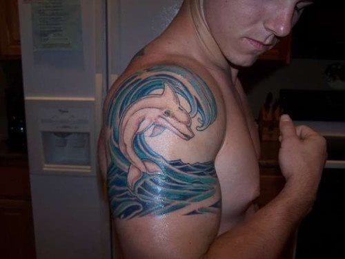 Este chico decidi tatuarse un delfin junto a las olas del mar