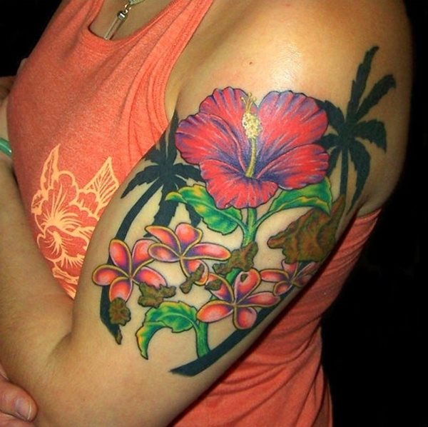 Tatuaje floral y muy hawaiano de unas flores de colores salmón muy vistosos y unas hojas también muy vivas, pero lo que realmente nos gusta de este tatuaje son las palmeras en color negro que se han puesto alrededor