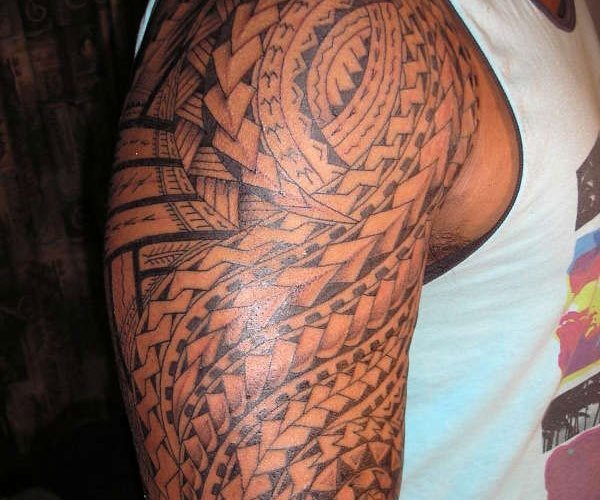 Tatuaje con motivos maori y tribales que ocupan todo el brazo y el cual se ha trazado con líneas redondeadas que vacn siguiendo los músculos que componen el brazo