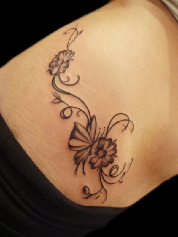 Tatuaje de un ramillete de flores en color negro, en la que predomina la buena curvatura conseguida para las cenefas y los pequeños y suaves sombreados trazados sobre las flores, un tatuaje muy bonito, que también quedaría bien si fuera a color