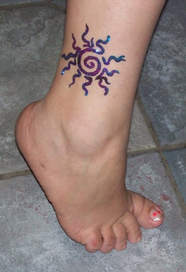 Tatuaje de un sol en el tobillo, aunque no parece que vaya a durar mucho, mientras lo tenga, disfrutará de un tattoo muy brillante y colorido que le da un toque genial a su piel, debería de animarse y hacer del tatto uno indefnido, para que lo disfrute siempre