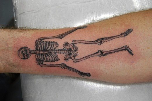 Un esqueleto completo a tamao escala tatuado en el antebrazo