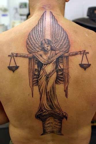Tatuaje de una mujer ángel con unas alas muy simétricas y que parece estar haciendo las veces de jueza con una balanza, tal vez un tatuaje muy acertado para todos aquellos a los que les guste el mundo del derecho y por qué no, un tatuaje para abogados