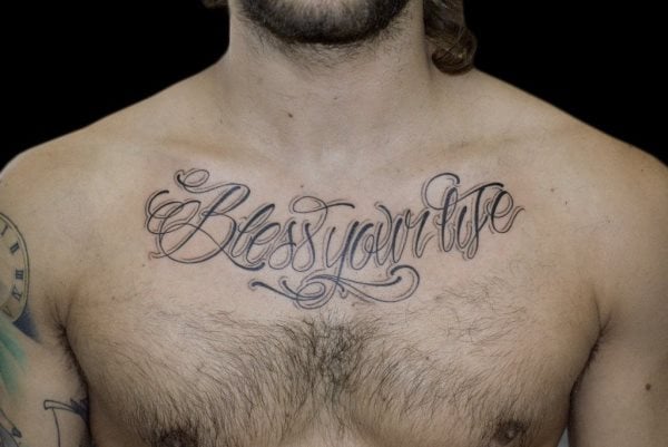 Tatuaje en el pecho de una frase inglesa que dice Bless your life, un tatuaje muy motivados para que todos aquellos que vean el tatuaje intenten aplicar en su vida, pero que seguro se lo ha tatuado esta persona para aplicárselo ella misma