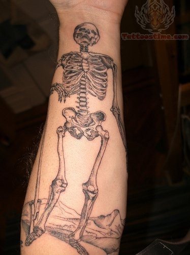 Un esqueleto tatuado sobre la parte interna del antebrazo