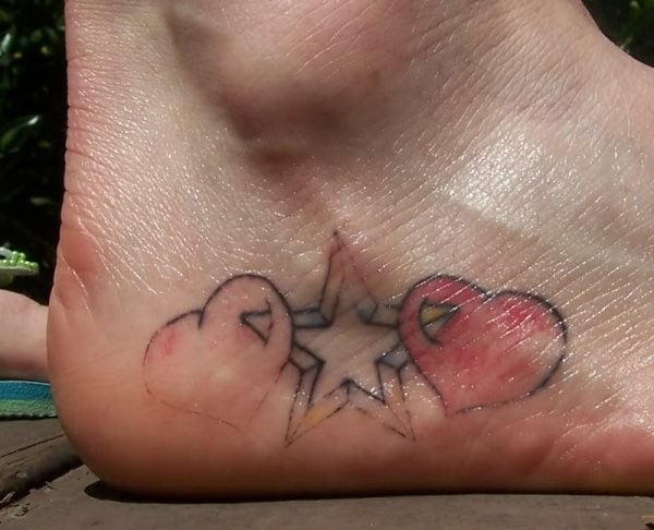 Dos corazones rodean a una estrella de cinco puntas, tatuadas bajo el tobillo y caracterizado por la sencillez de las líneas y trazos del tatuaje