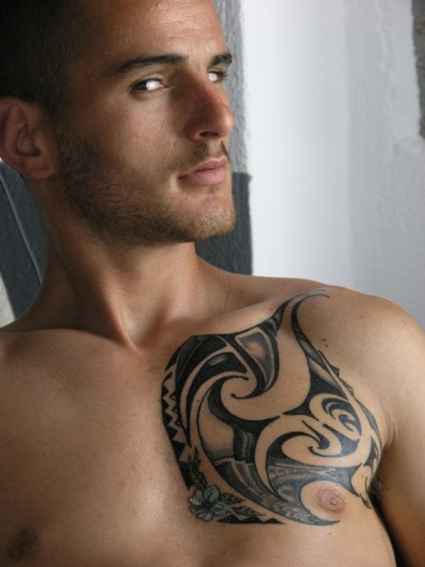 Hombre con un diseño tribal hawaiano en la parte izquierda de su pecho, justo en la zona del corazón