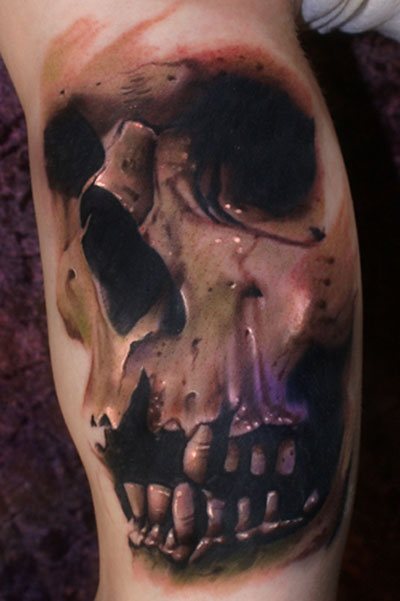 Tatuaje de una calavera muy peculiar ya que no ha sido necesario definir la silueta del craneo para conseguir un maravilloso resultado, gracias en parte a la gran profundidad que se ha conseguido en la nariz y los ojos, además de en la boca donde la falta de algunos dientes reflejan el paso del tiempo