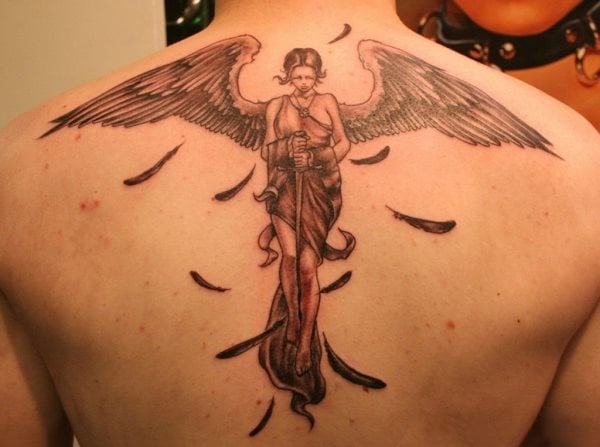 Tatuaje de una mujer alada con una espada entre sus manos y agarraad con las piernas, a la que de sus alas se han desprendido algunas plumas que dan un aspecto sensacional a todo el tatuaje, una magnífica idea la de las plumas cayendo