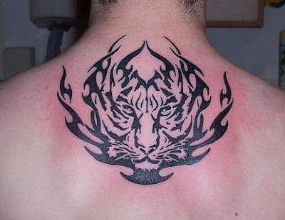 Tatuaje de la silueta de un tigre rodeado por tribales en forma de llama que ocupan todo el centro de la espalda de este hombre, un tatuaje original para ser de un tigre, ya que nos cuesta trabajo ver tatuajes originales de estos animales y en esta ocasión, al menos se han realizado detalles para hacerlo diferente Tatuaje de la silueta de un tigre rodeado por tribales en forma de llama que ocupan todo el centro de la espalda de este hombre, un tatuaje original para ser de un tigre, ya que nos cuesta trabajo ver tatuajes originales de estos animales y en esta ocasión, al menos se han realizado detalles para hacerlo diferente