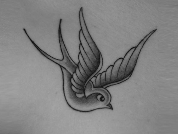 Sencillo tatuaje de un pájaro que parece ser una golondrina y para el que sólo se ha utilizado el color negro, está situado en una parte disimulada del cuerpo y destacamos los bonitos ojos que se le han pintado al pájaro